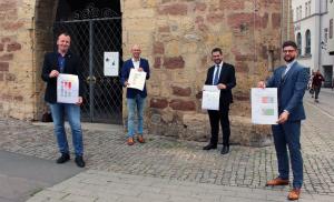 Vier Männer stehen vor dem historischen Rathaus in Jena und präsentieren die Ergebnisse der Unternehmensbefragung.