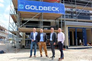 Vier Männer stehen vor der Baustelle der FBGS Technologies GmbH im Gewerbegebiet Jena21.
