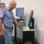 Ein Mann in einem blauem Hemd testet einen Fingerabdruckscanner. 