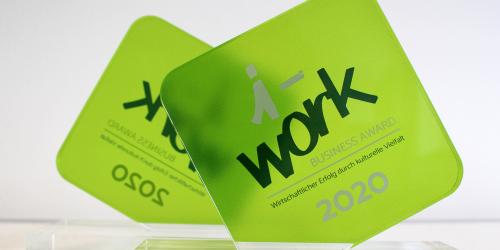 Das Symbolbild zeigt zwei grüne i-work Business Awards, die hintereinander aufgestellt sind.