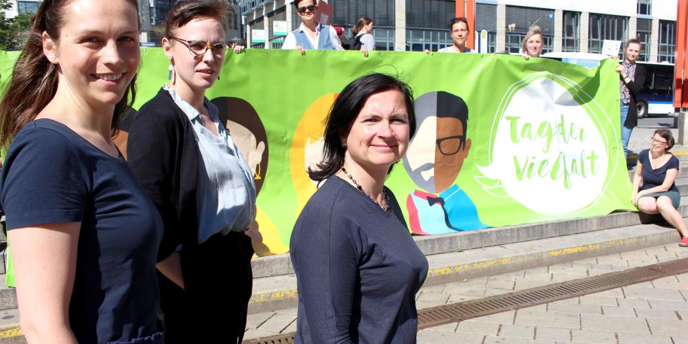 Akteur:innen präsentieren ein Banner und freuen sich auf den Tag der Vielfalt am 31. Mai in Jena