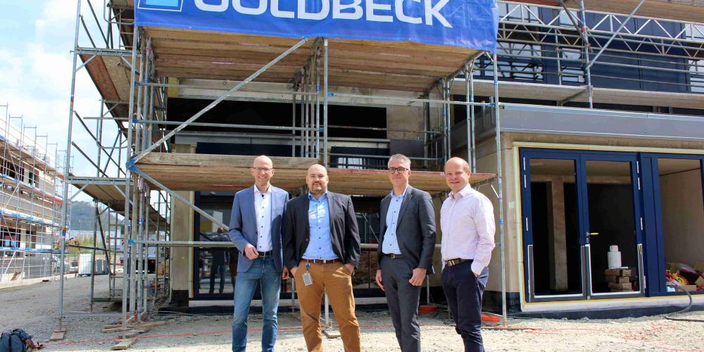 Vier Männer stehen vor der Baustelle der FBGS Technologies GmbH im Gewerbegebiet Jena21.