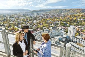 Drei Personen auf dem JenTower im Gespräch. 