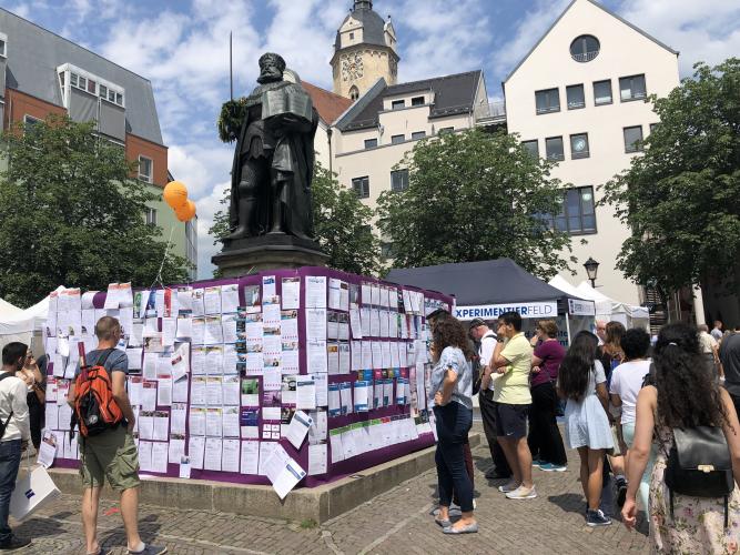 Blick auf den Marktplatz, Zettel an Stellwänden mit Jobangebote, Denkmal Hanfried im Hintergrund Stadtkirche