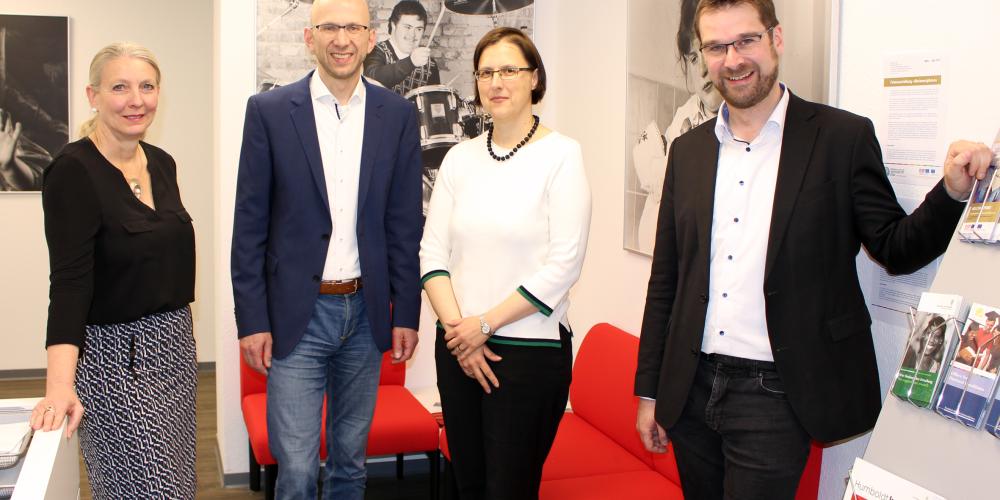 4 Personen schauen in die Kamera.