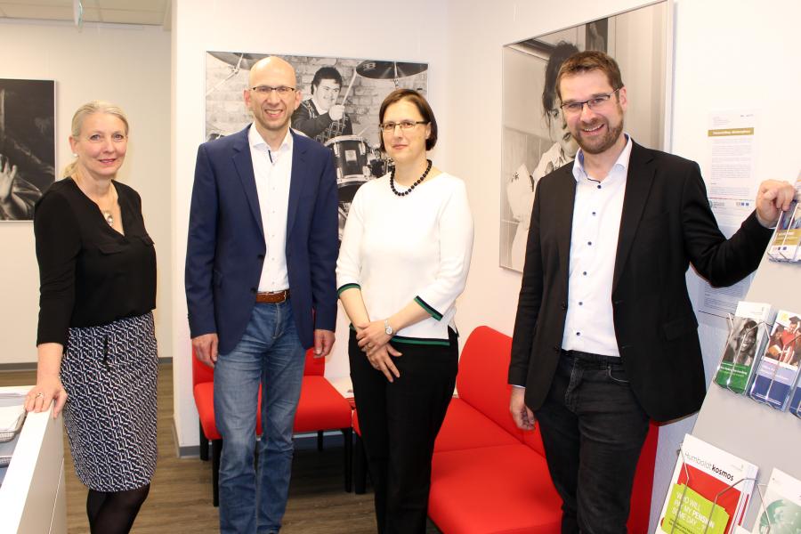 4 Personen schauen in die Kamera.