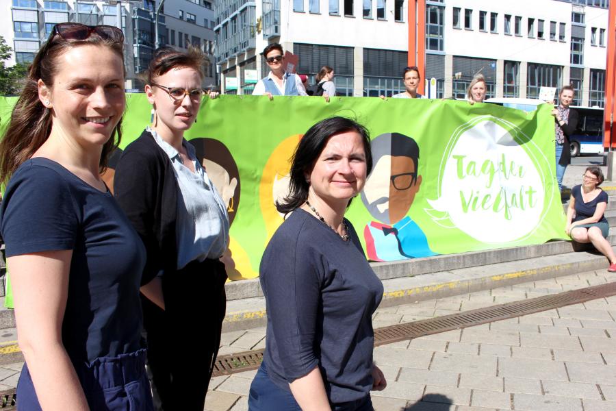 Akteur:innen präsentieren ein Banner und freuen sich auf den Tag der Vielfalt am 31. Mai in Jena