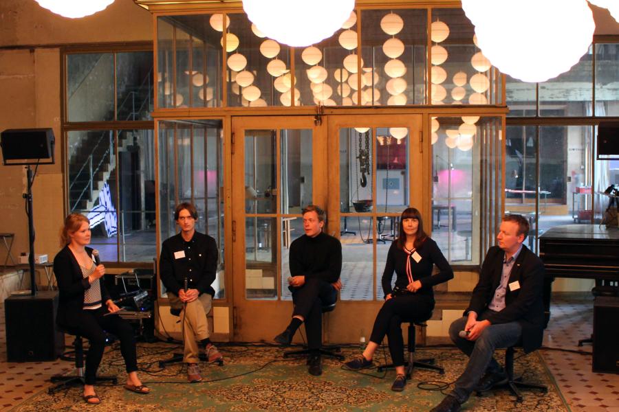 Fünf Menschen sitzen auf einem Podium und führen eine Diskussion über das Thema Zwischennutzung.