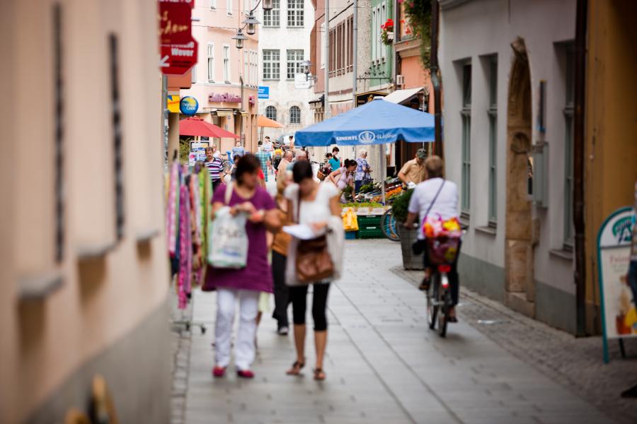 Zwei Frauen schlendern mit vollen Tüten durch die Jenaer Innenstadt.