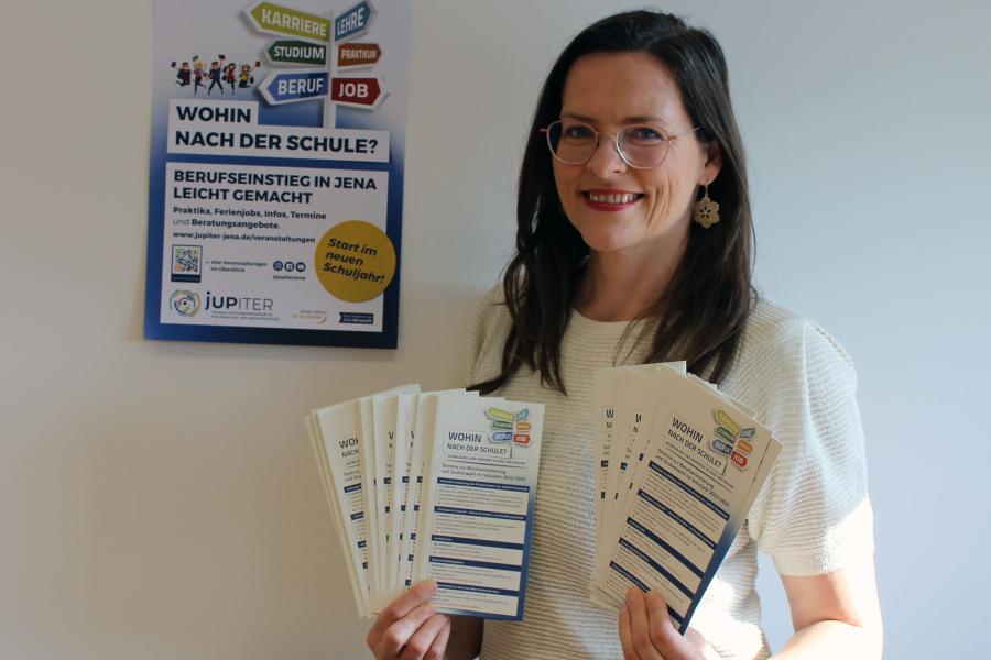 Eine Frau mit dunklen Haaren präsentiert die neuen Flyer von "Wohin nach der Schule" für das Jahr 2022.